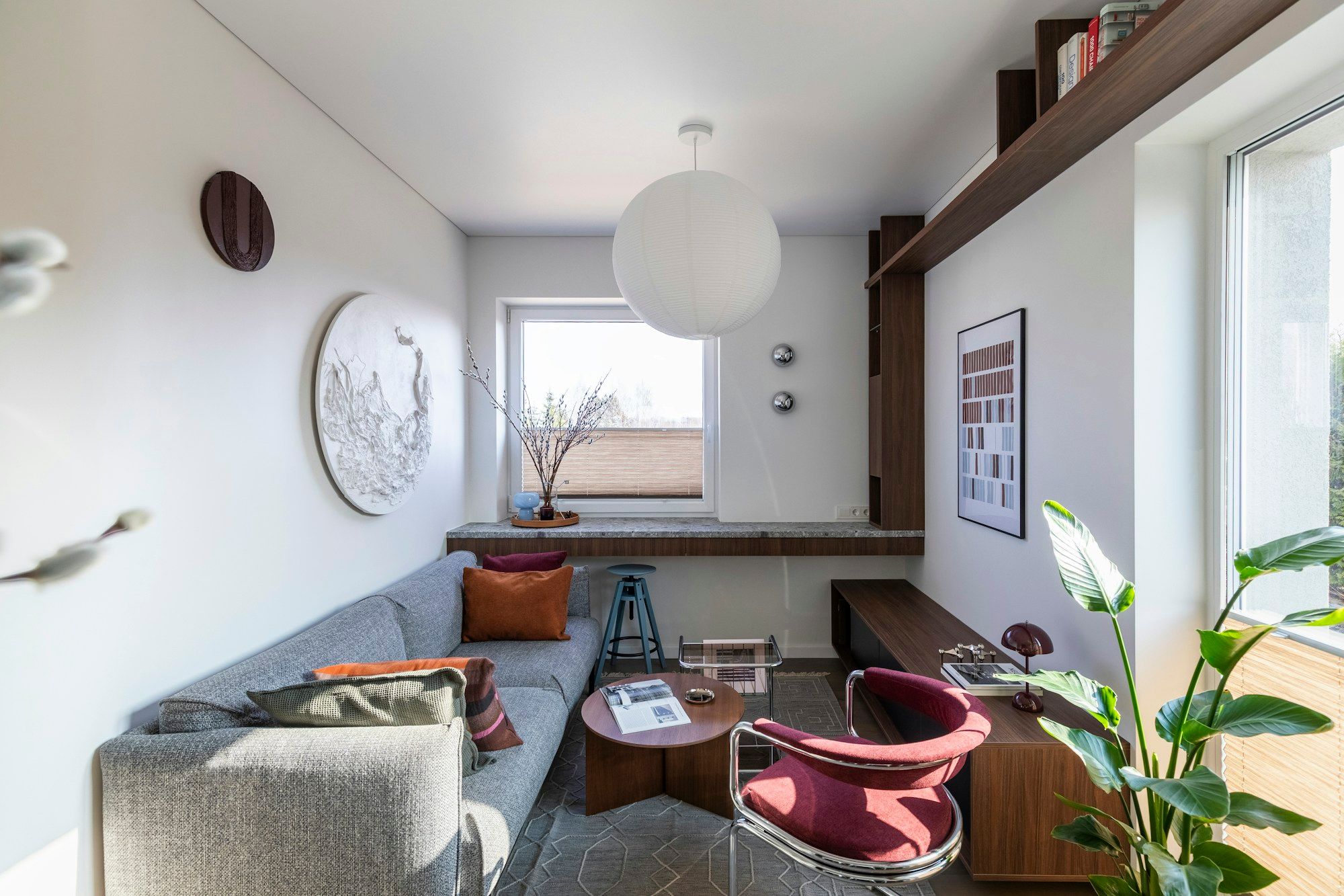 Ruhiger Raum mit Sofa, Sessel und Pflanzen
